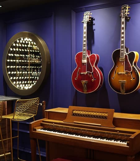 Inception mirror displayed with classic Gibson guitars